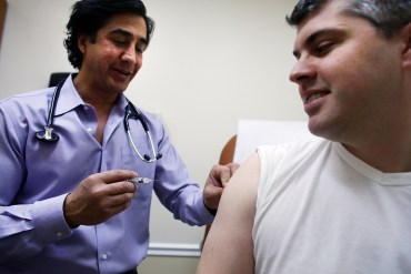 Aaron Lemma receives a flu shot from Dr. Sassan Naderi at the Premier Care walk-in health clinic which administers flu shots on in 2013 in New York City. (Photo by Spencer Platt/Getty Images)