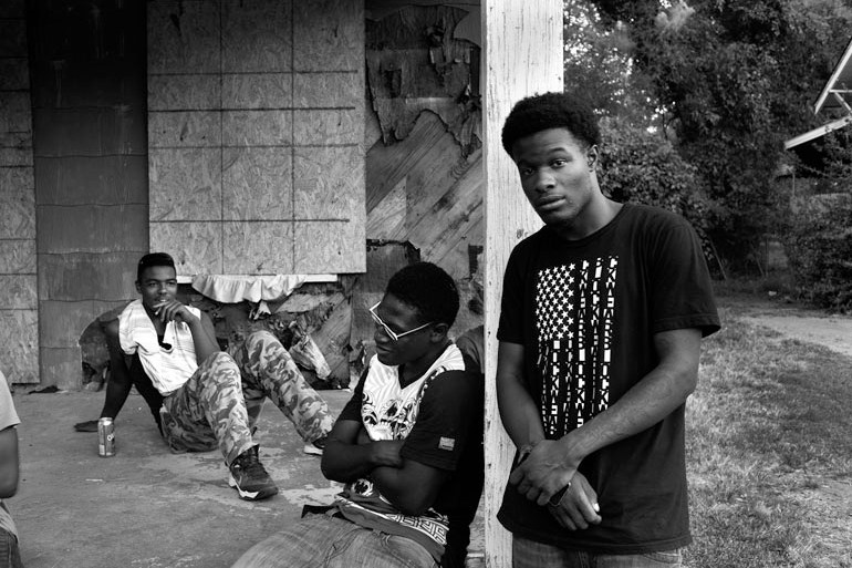 Young people in Mississippi are dealt a tougher hand than those in most other states. The state ranks last in life expectancy, per capita income, and children’s literacy. Here, three young men hang out on Winter Street in Jackson, the state capital. (Photo by Jon Lowenstein)