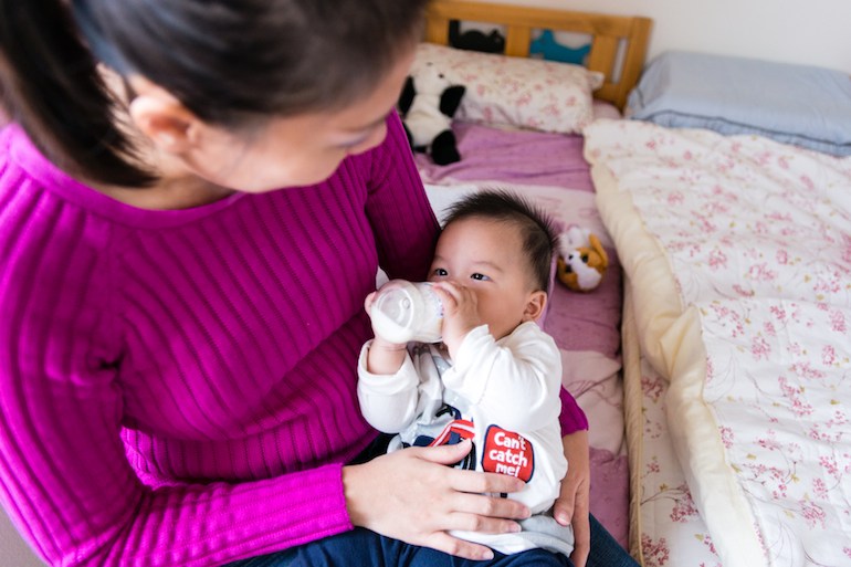Cecily Liu, 37, feeds her 6-month-old son Nolan Liu. She had trouble adding him to the Blue Shield insurance plan she purchased through the state health exchange (Photo by Heidi de Marco).