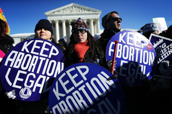 Pro-choice activists hold signs as marchers of the annual March for Life arrive in front of the U.S. Supreme Court January 22, 2014 on Capitol Hill in Washington. (Photo by Alex Wong/Getty Images)