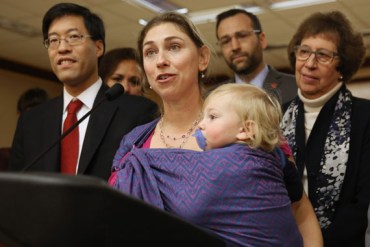 Leah Russin, of Palo Alto, holds her son, Leo, 16 months, as she speaks in support of proposed legislation that would require parents to vaccinate all school children, during a news conference in Sacramento, Calif., Wednesday Feb. 4, 2015.  If approved by the Legislature and signed by the governor, the bill, co-authored by Sen. Richard Pan, D-Sacramento, left, and Ben Allen, D-Santa Monica, second from right,  would make California one of only three states requiring such restrictions.  At right is Sen. Lois Wolk, D-Davis who supports the measure.(AP Photo/Rich Pedroncelli)