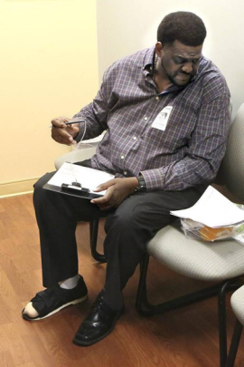 Vincent Adderly, 46, of Miami Gardens fills out forms in the medical records office at Memorial Hospital West in Pembroke Pines on Thursday, May 28, 2015. He is uninsured and diabetic and was at the hospital following his week- long hospitalization there. Part of the big toe on Adderly's right foot had to be amputated. (Photo by Marsha Halper/Miami Herald)