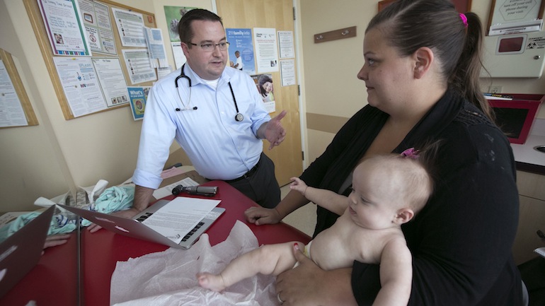 Dr. RJ Gillespie (left) talks with Sarah Pike about her family history during a routine exam for four-month-old Payton Pike at The Children's Clinic in Portland, September 3, 2015 (Kristyna Wentz-Graff/The Oregonian).