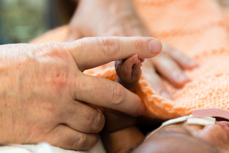 Kate Teague, a registered nurse at Lucile Packard Children's Hospital in Palo Alto, California, holds a premature baby’s hand on Tuesday, October 20, 2015 (Photo by Heidi de Marco/KHN).