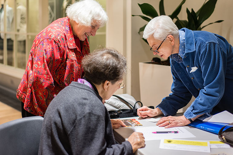 Ann Morales, secretary of the mall walking group at Mazza Gallerie in Washington, D.C., signs in participants on Tuesday, March 15, 2016. (Heidi de Marco/KHN)