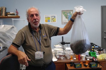 At the Broward County Mosquito Control office in Pembroke Pines, Fla., biologist Evaristo Miqueli holds a bag of thousands of dead mosquitos his agency has caught in 2016. (Phil Galewitz/KHN)
