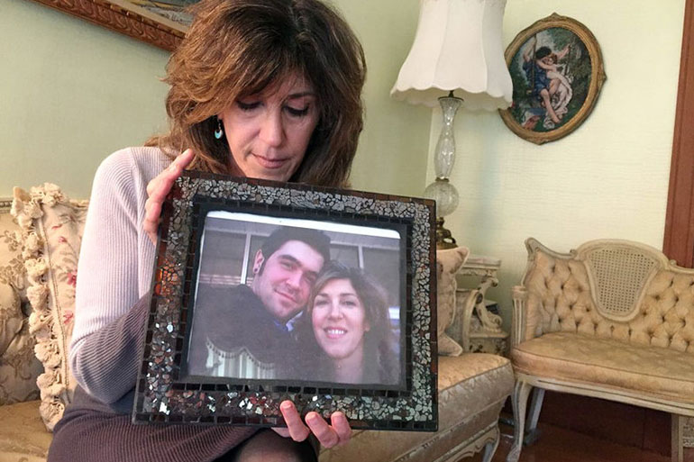 Debbie Deagle holds a photo of her son Stephen and herself. (Martha Bebinger/WBUR)