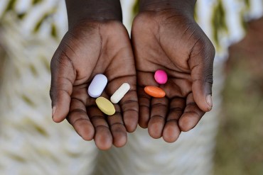Medicine Healthcare Symbol. Black African boy holding pills to cure diseases. Unfortunately, in Africa there are lots of diseases like malaria, pneumonia, AIDS or simple Diarrhoea. Thereforem, medicine and healthcare pills are very important in the black continent.