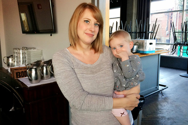 Keely Edgington and her daughter, Lula, pose inside their family-owned restaurant, Julep, in Kansas City, Mo. Lula was diagnosed with a neuroblastoma when she was 9 months old. She's now 16 months old. (Alex Smith/KCUR)