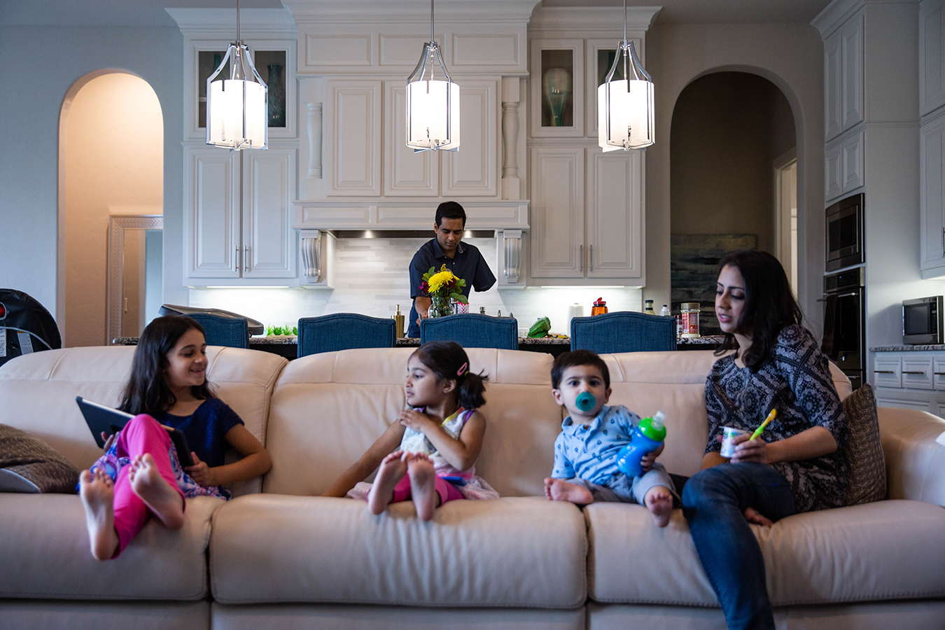 Khan cooks lunch for his wife, Ayesha, and children, Nazneen, 7, Yasmeen, 4, and Rehan, 1, in their home in Southlake, Texas.