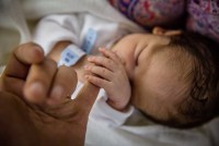 Newborn baby gripping their mother's hand