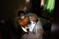 Doctor talking to senior female patient in a home visit