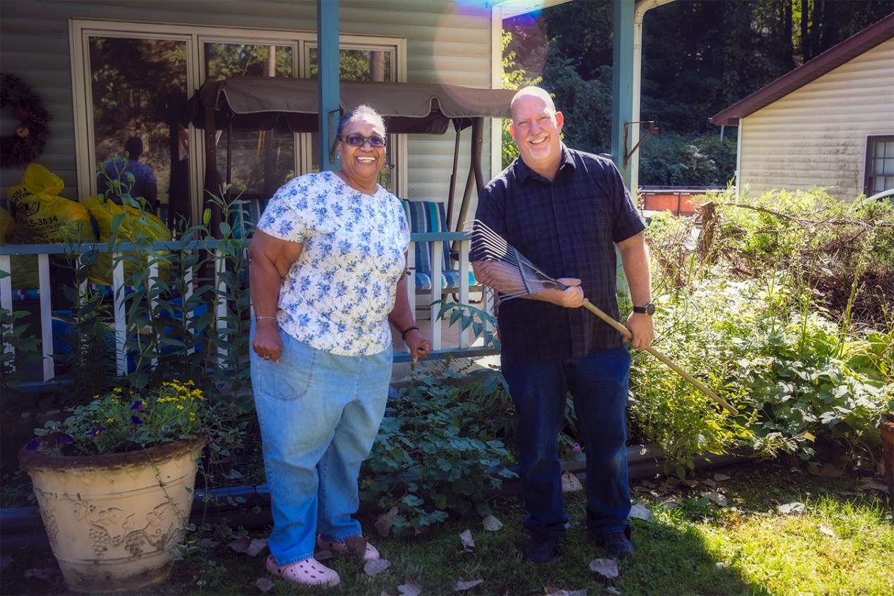 Tim Barrage stands next to Gloria Bailey outside her home in Akron, Ohio.