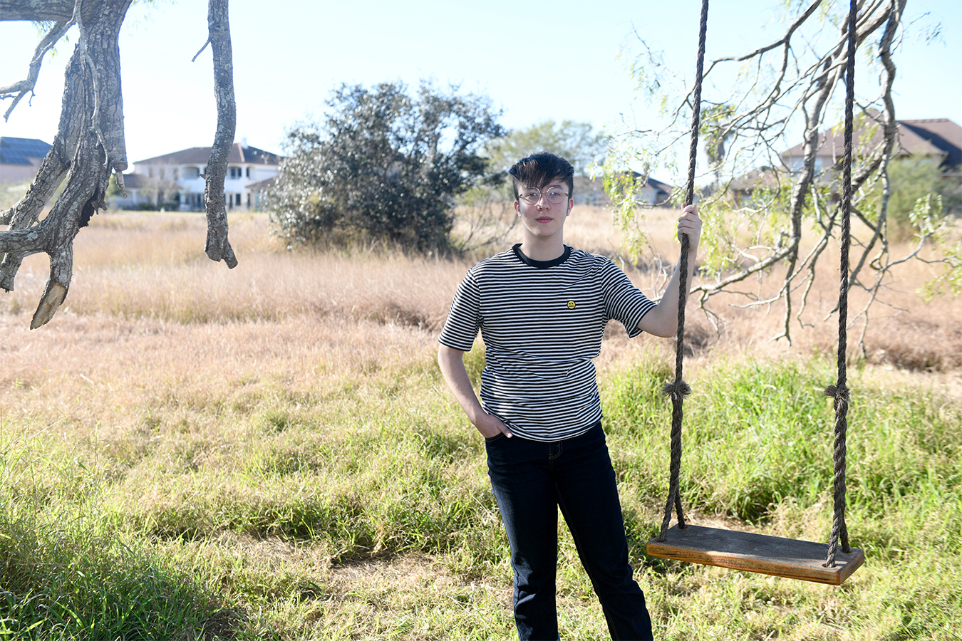 Charlie Apple stands next to a swing outside his home in Corpus Christie, Texas.