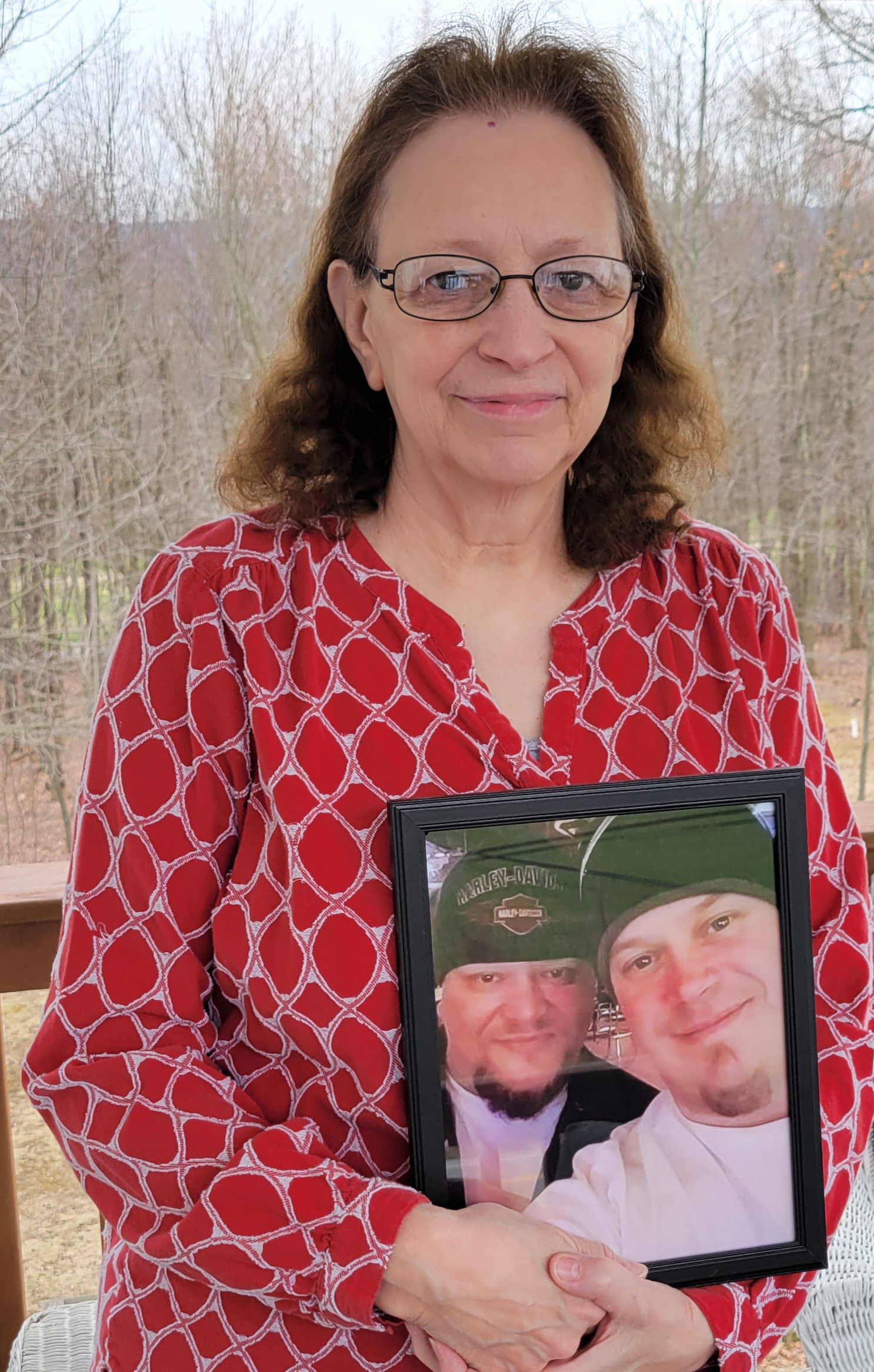Connie Houtz was seen standing outside her home, holding a photograph of her sons Toby and Eric Delamarter.  In the photograph she is holding, the boys are standing there laughing.