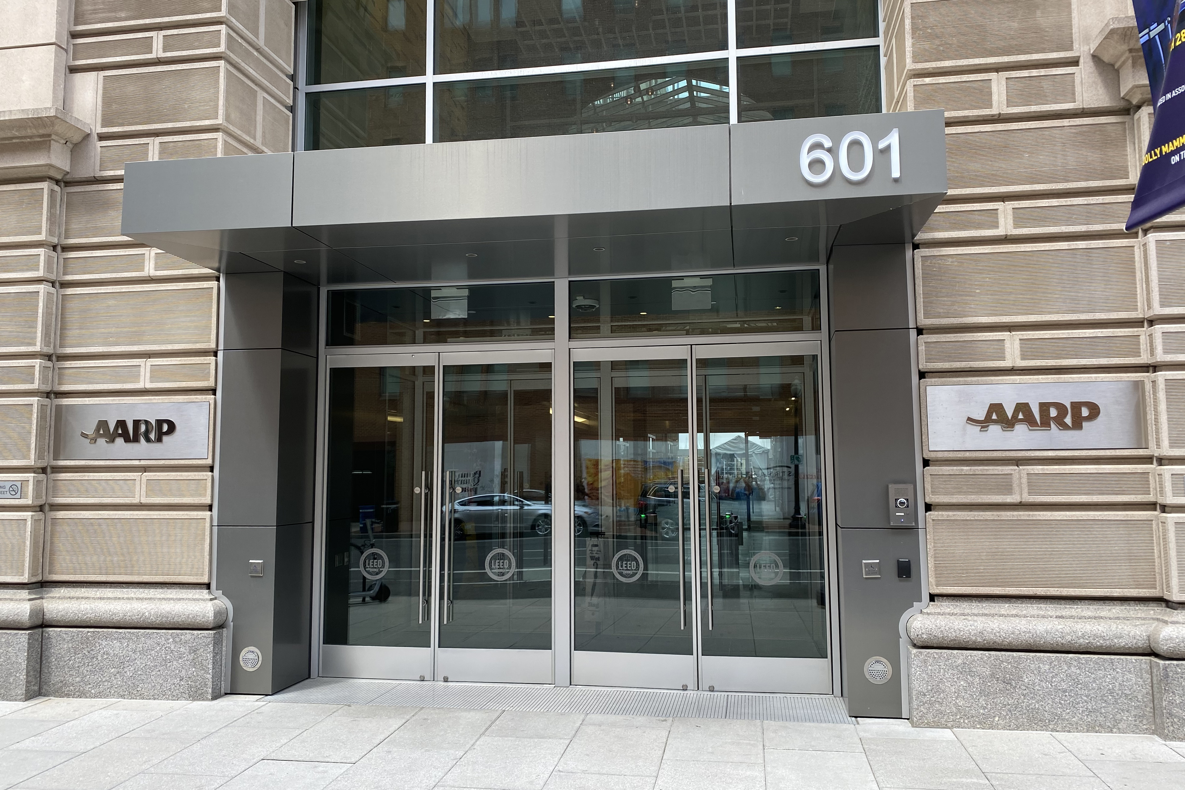 The exterior of an office building with glass doors at its entrance is seen in Washington. The AARP logo is emblazoned on the walls on each side of the entrance.