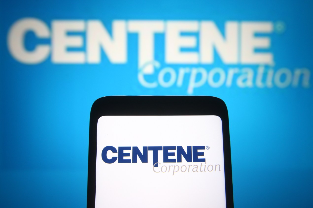 In this photo illustration the Centene Corporation logo of an insurance company is seen on a smartphone and a pc screen.