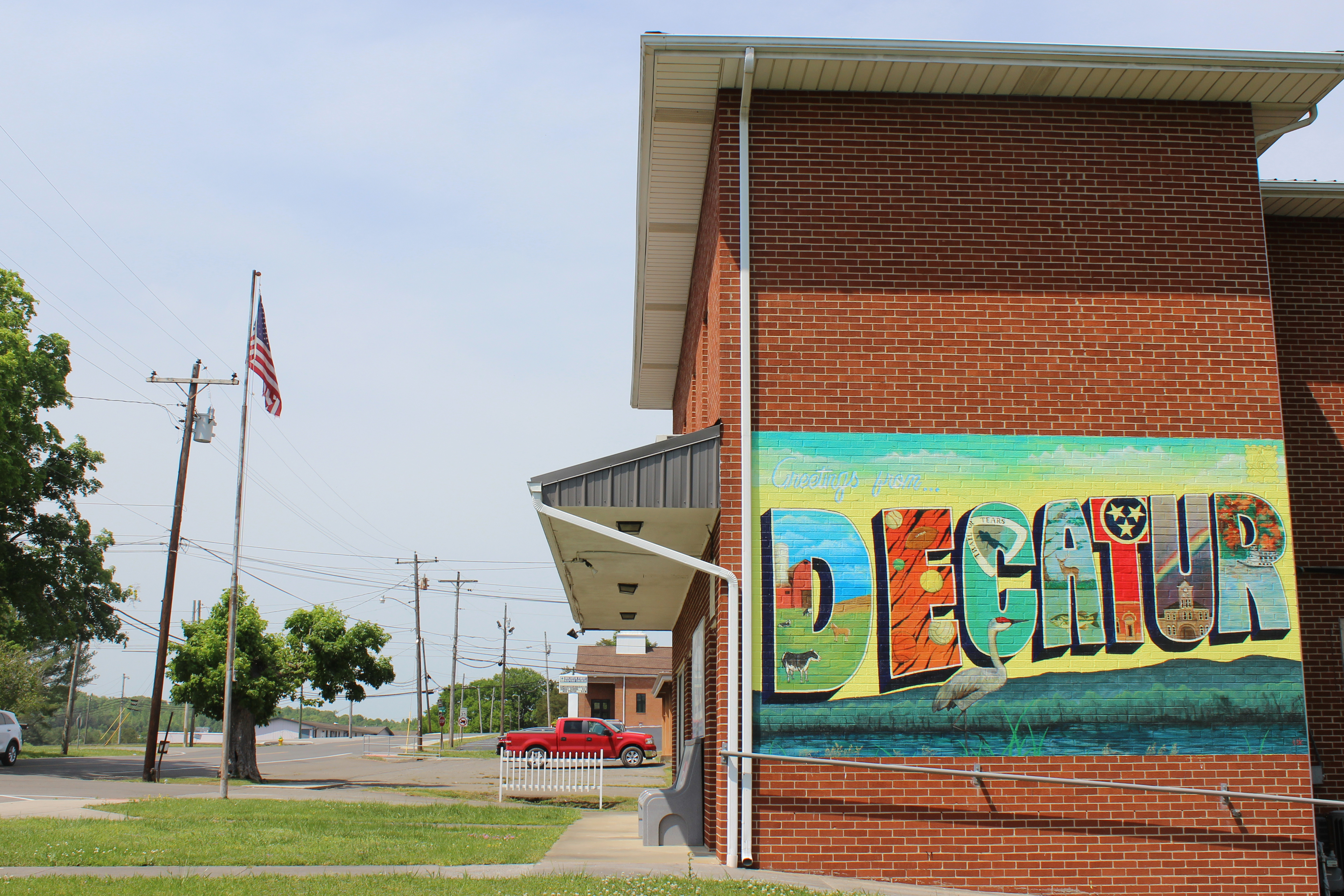 A building displays a mural with text that reads, "DECATUR," in bright colors.