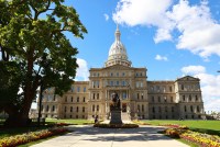A wide shot of the Michigan State Capitol building is seen on a sunny day.