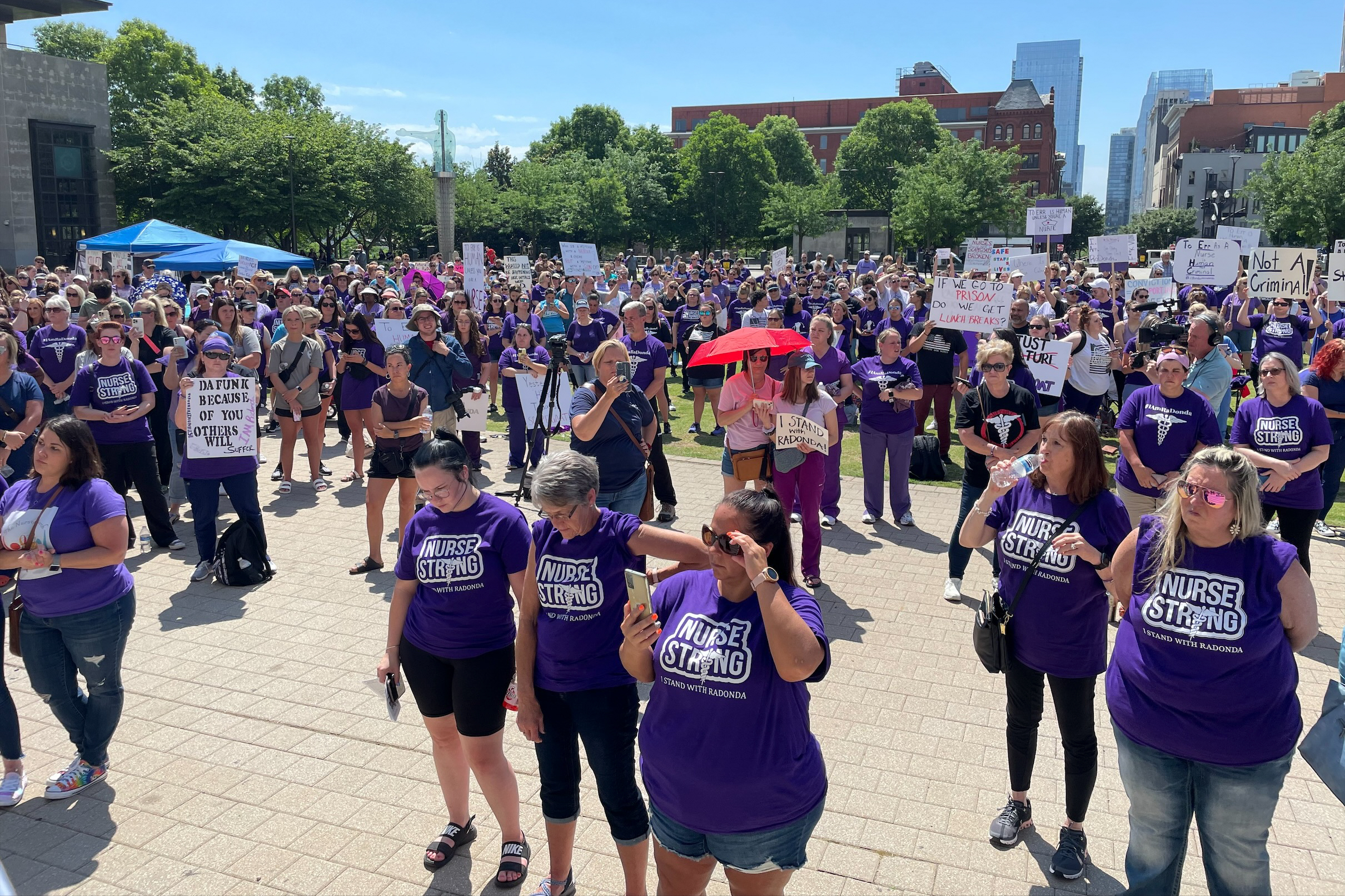 A crowd of hundreds is seen gathered near the Davidson County Courthouse in Nashville. The demostrators wear purple shirts that read, "Nurse Strong. I stand with RaDonda." 