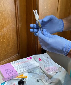 A closeup photo of Dr. Herring's gloved hands shows a syringe of Sublocade.