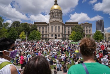 A photo shows a crowd of pro-abortion activists holding signs and banners outside the Georgia Capitol.