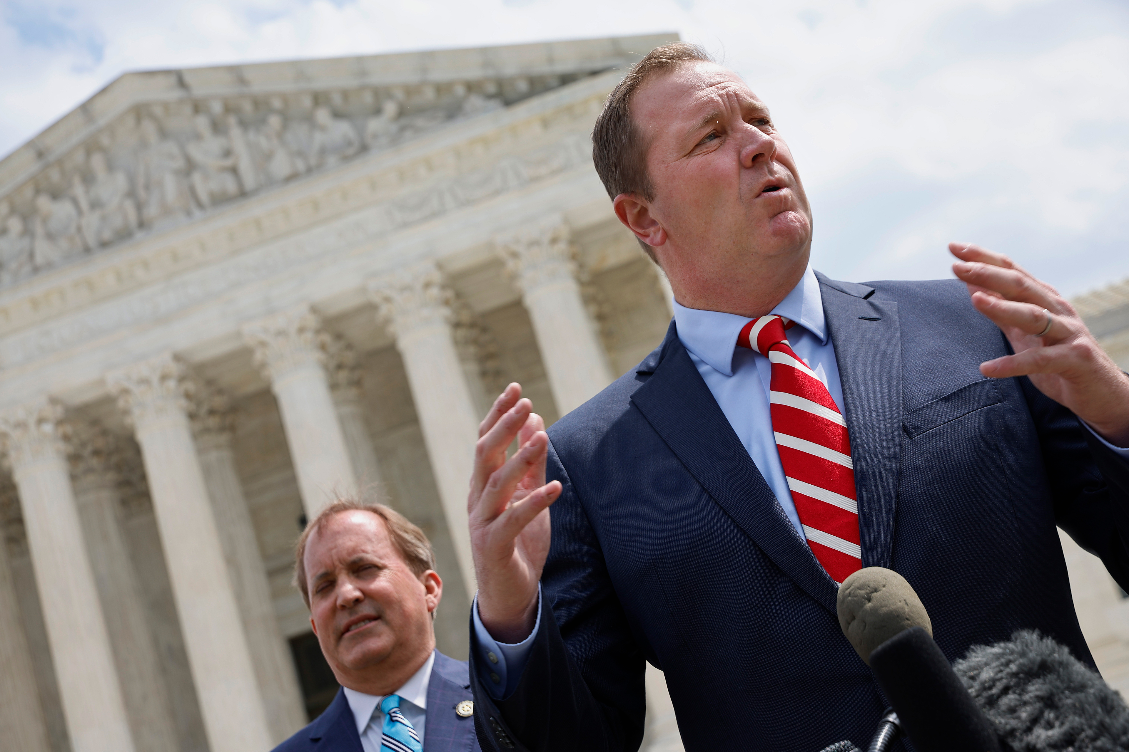 A photo shows Eric Schmitt speaking to reporters in front of the U.S. Supreme Court.