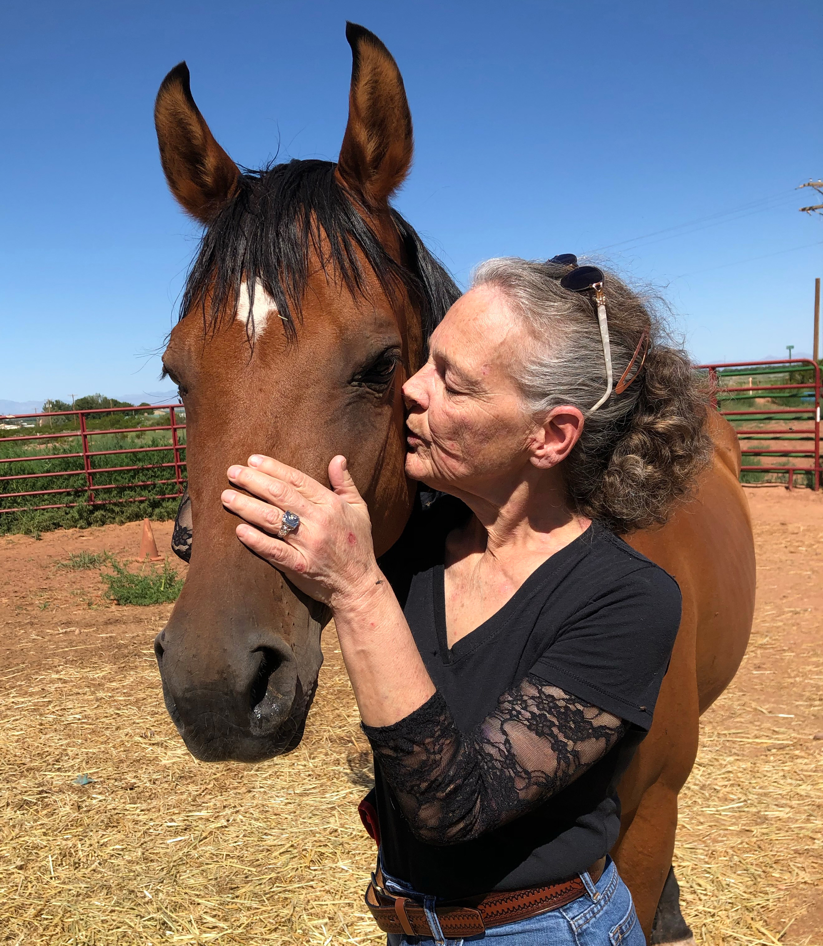 A photo shows Suzanne BeHanna posing for a photo with a horse.