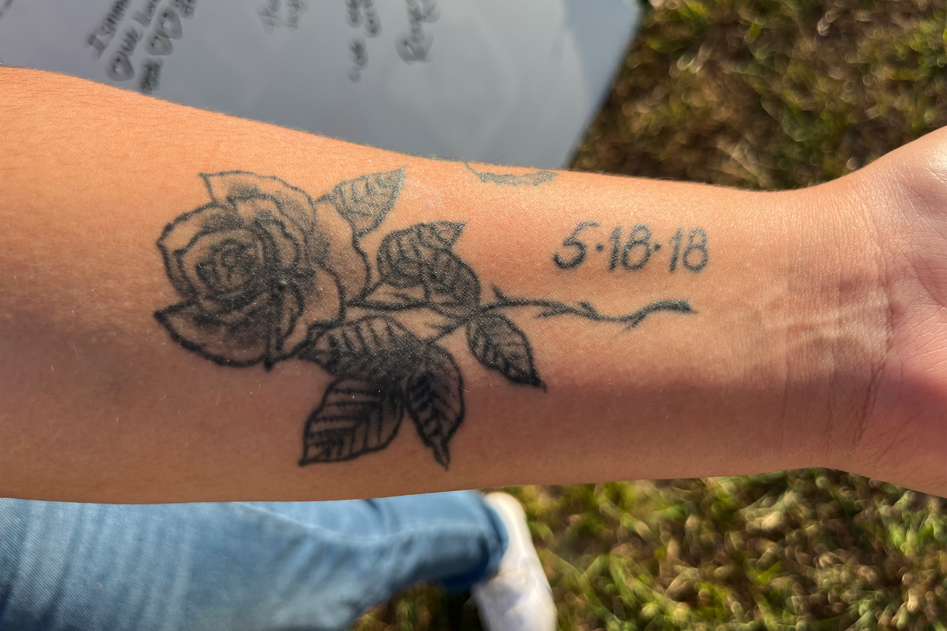A photo of Reagan Gaona's wrist shows a black and gray rose tattoo with the date next to it: May 18, 2018.