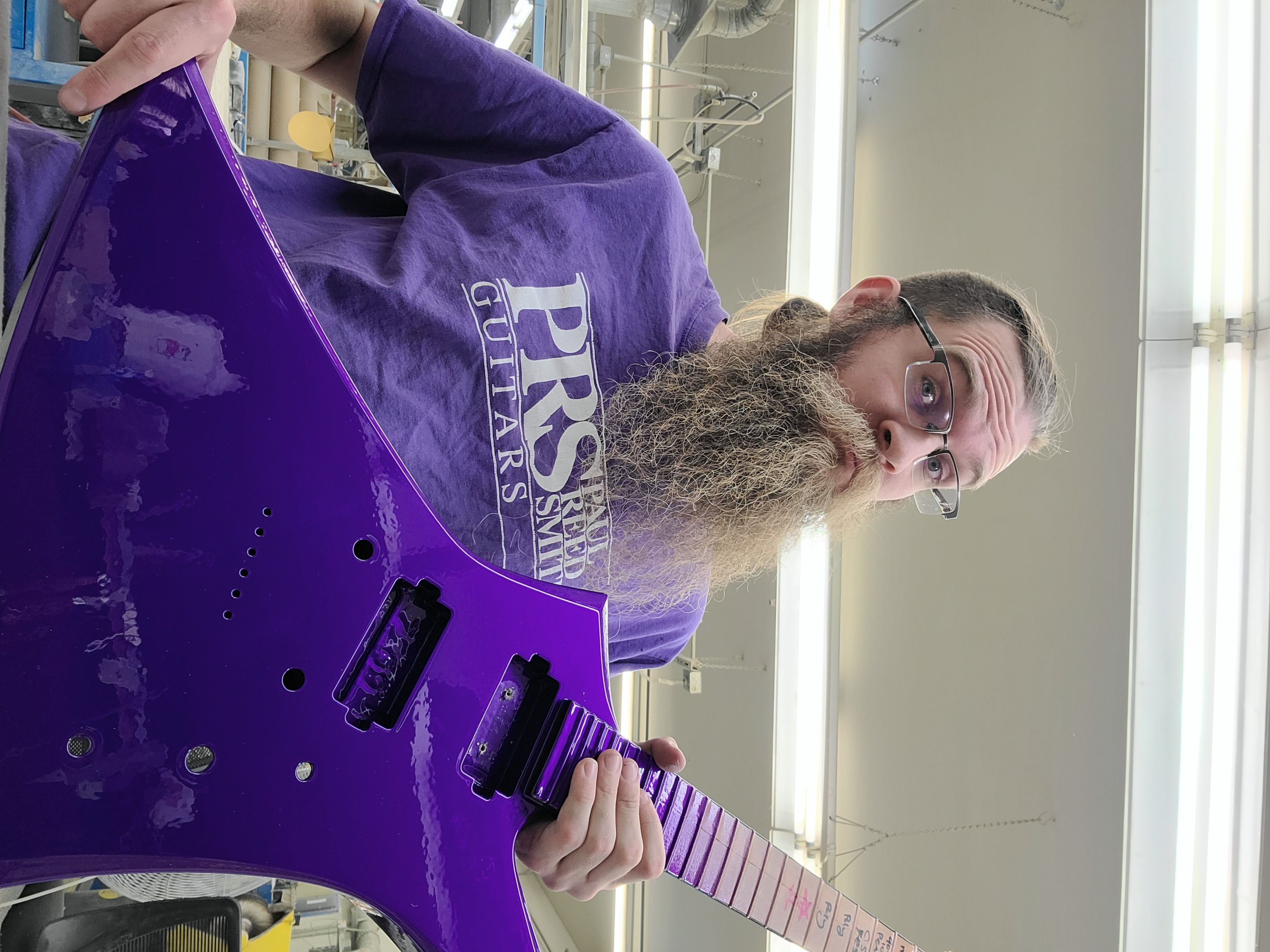 A photo shows Nathan Songne posing for a selfie with a purple guitar.
