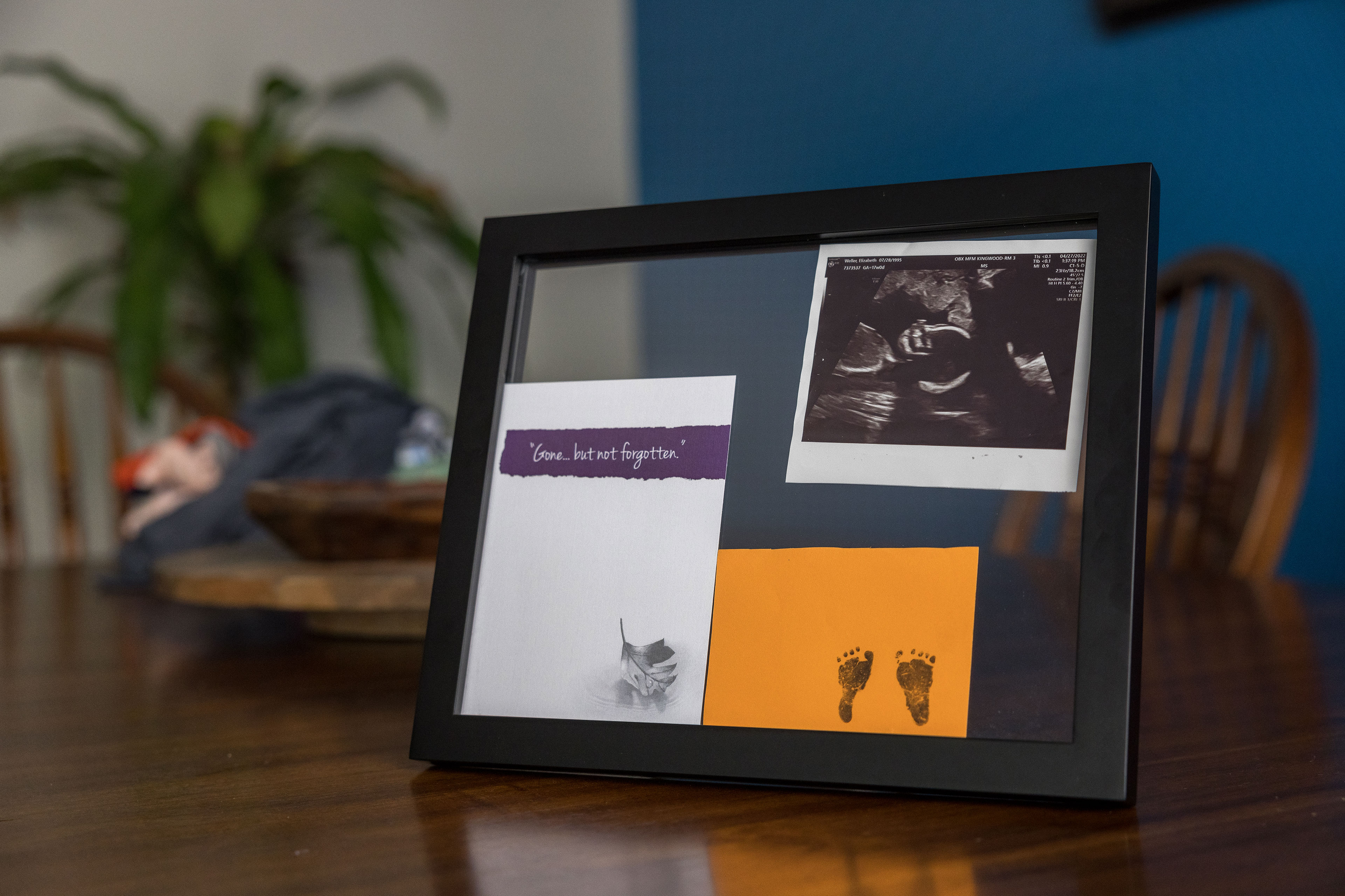 A frame holds a sonogram, a card with small footprints, and a card that says 