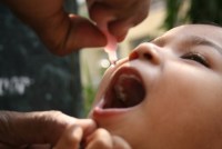 A photo shows a child receiving an oral polio vaccine.