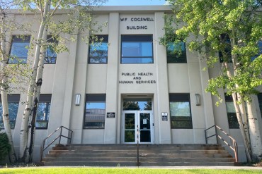 A photo shows the exterior of Montana's Department of Public Health and Human Services.