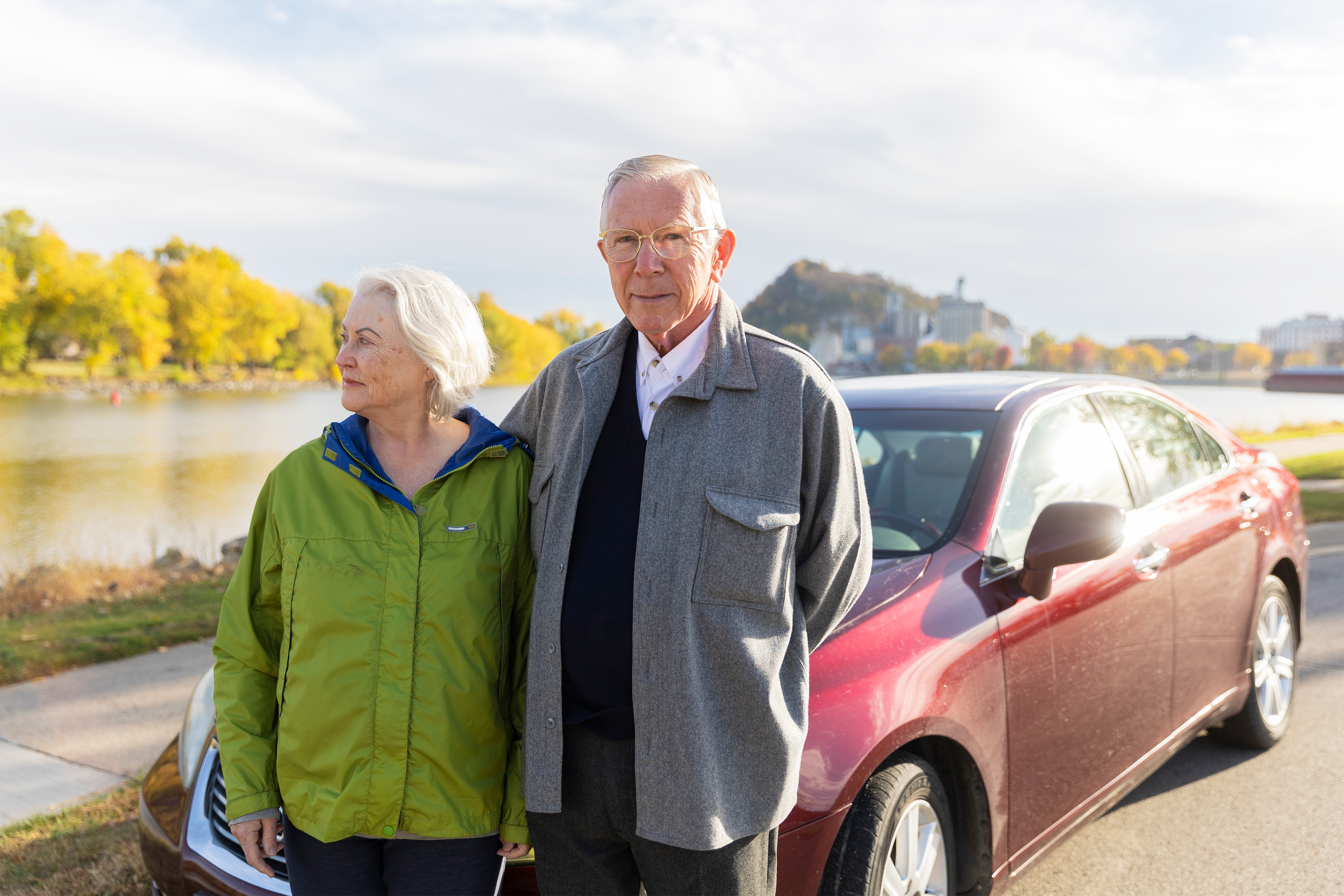 One photo shows Jim and Judie Maybach together standing outside their car.  The city of Red Wing, Minnesota, is seen behind them.
