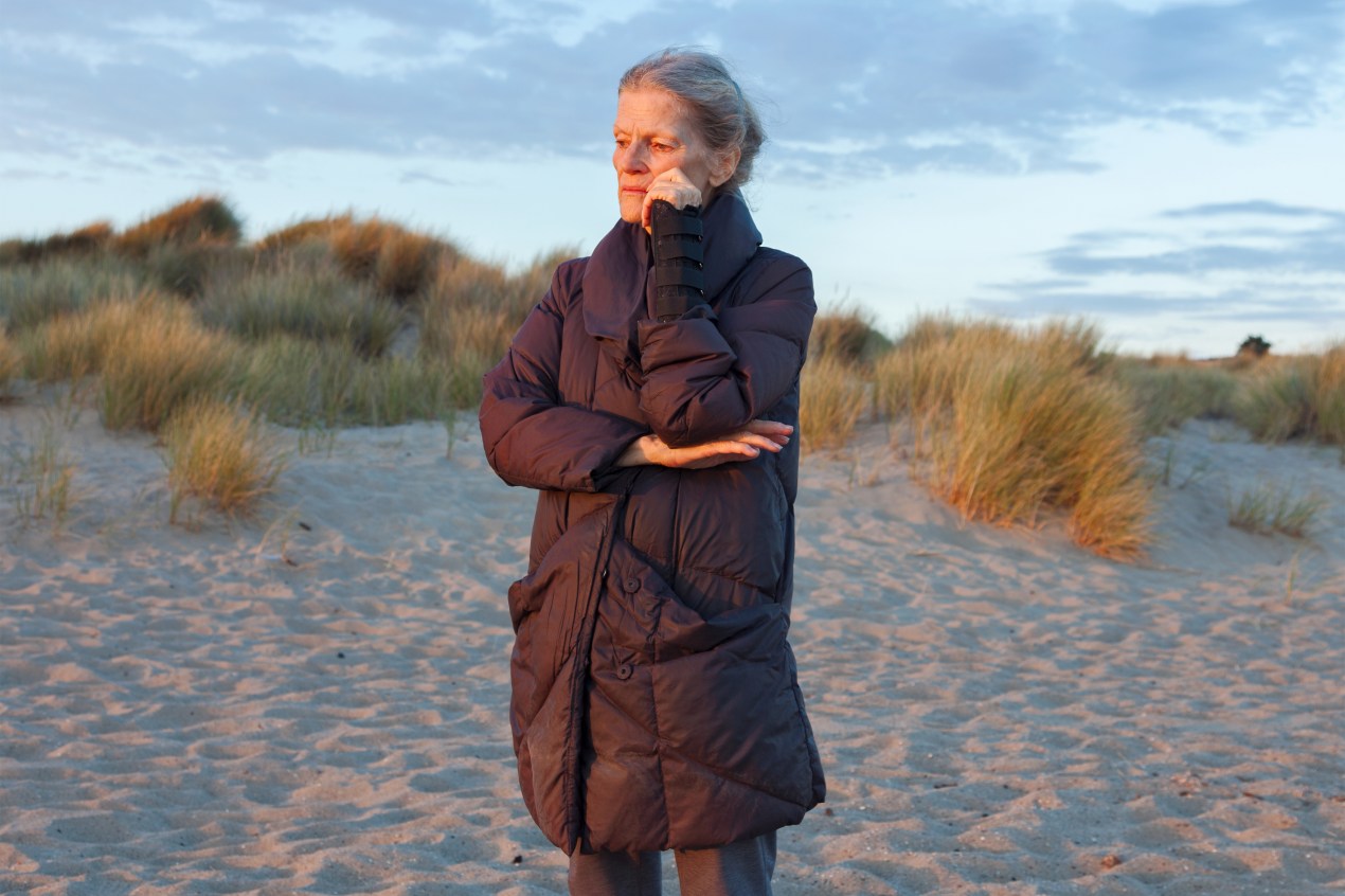 A photo shows Marna Clarke standing on a beach, looking to the side.