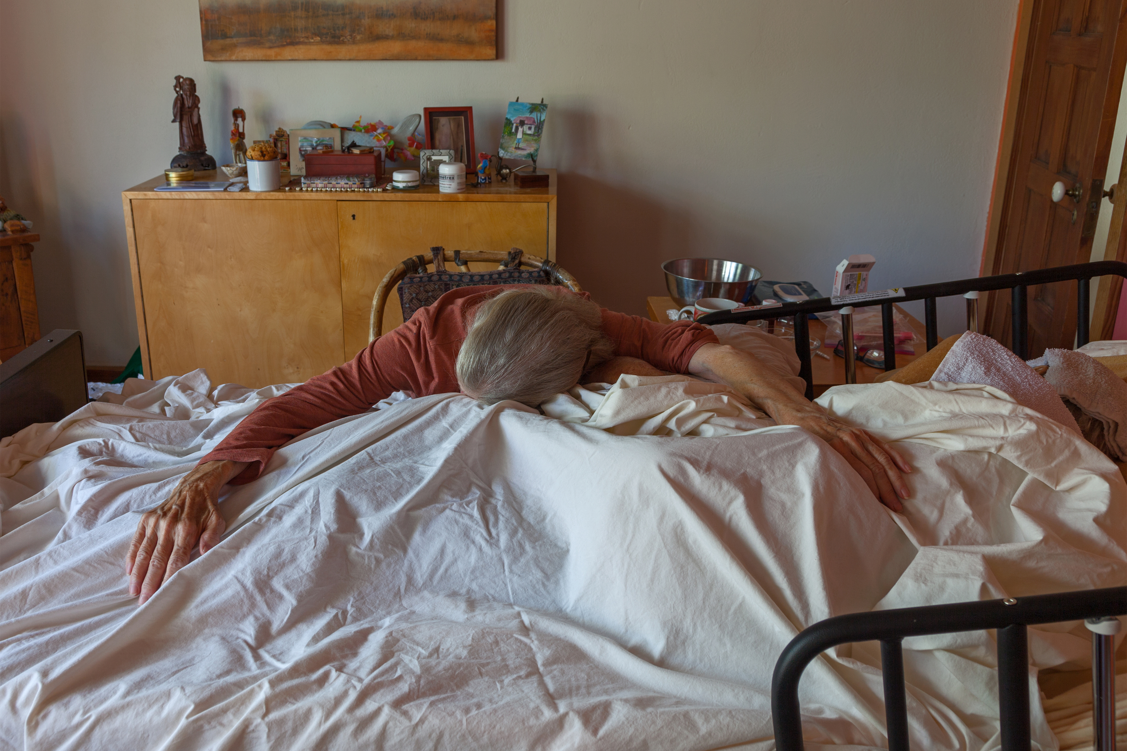 A photo shows Marna Clarke resting her head on her partner's deathbed.
