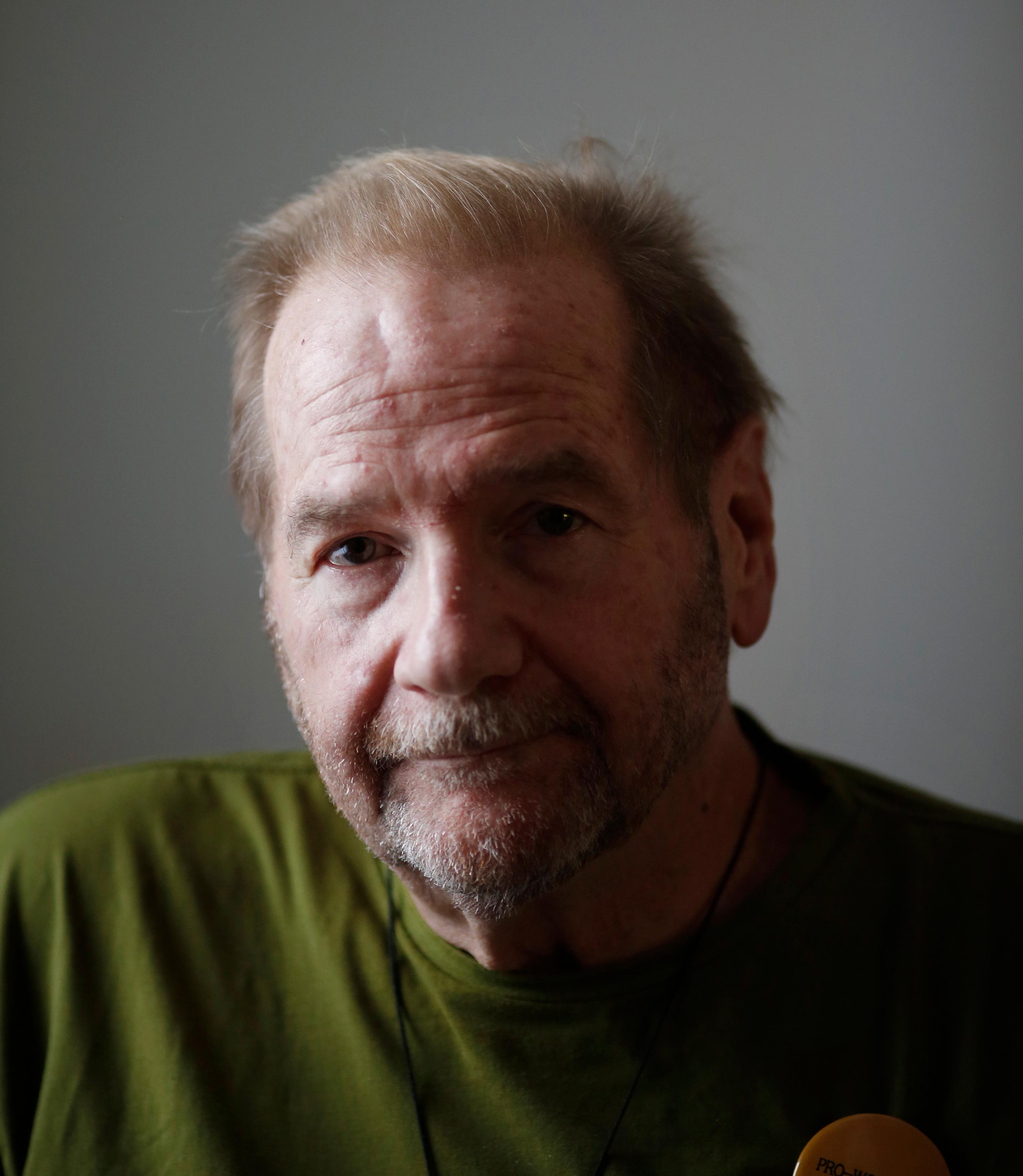 A photo shows Jerry Bilinski posing for a portrait by a window, casting the right side of his face in shadow.