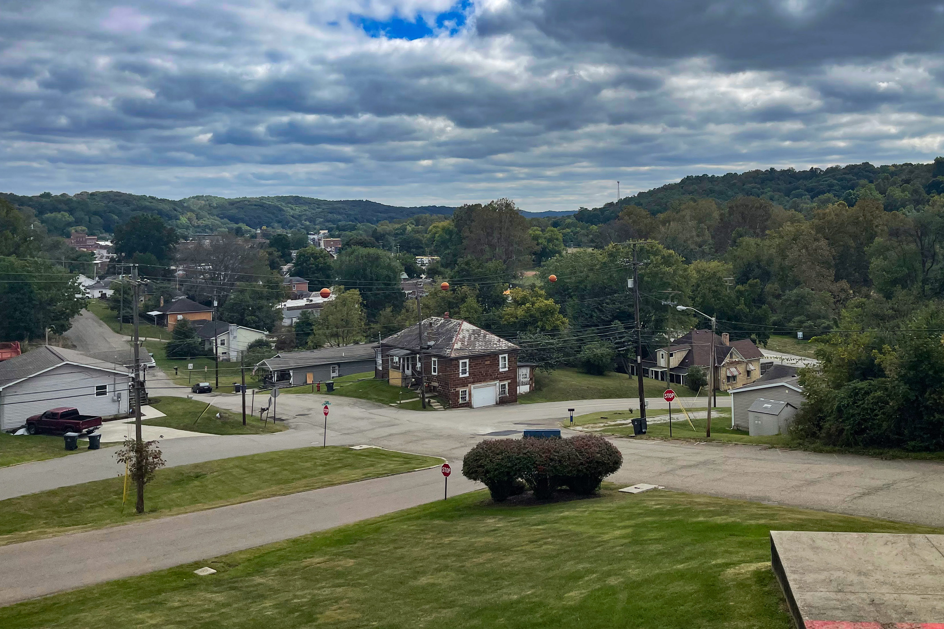 Photo shows a view of downtown Nelsonville, Ohio.  It is a grassy, ​​hilly area with wide roads.