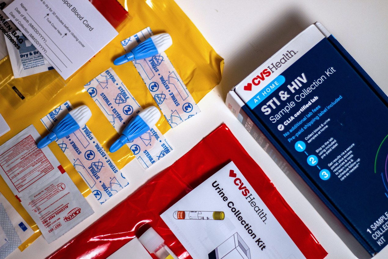 A photo shows a CVS home STI test on a counter next to its contents.