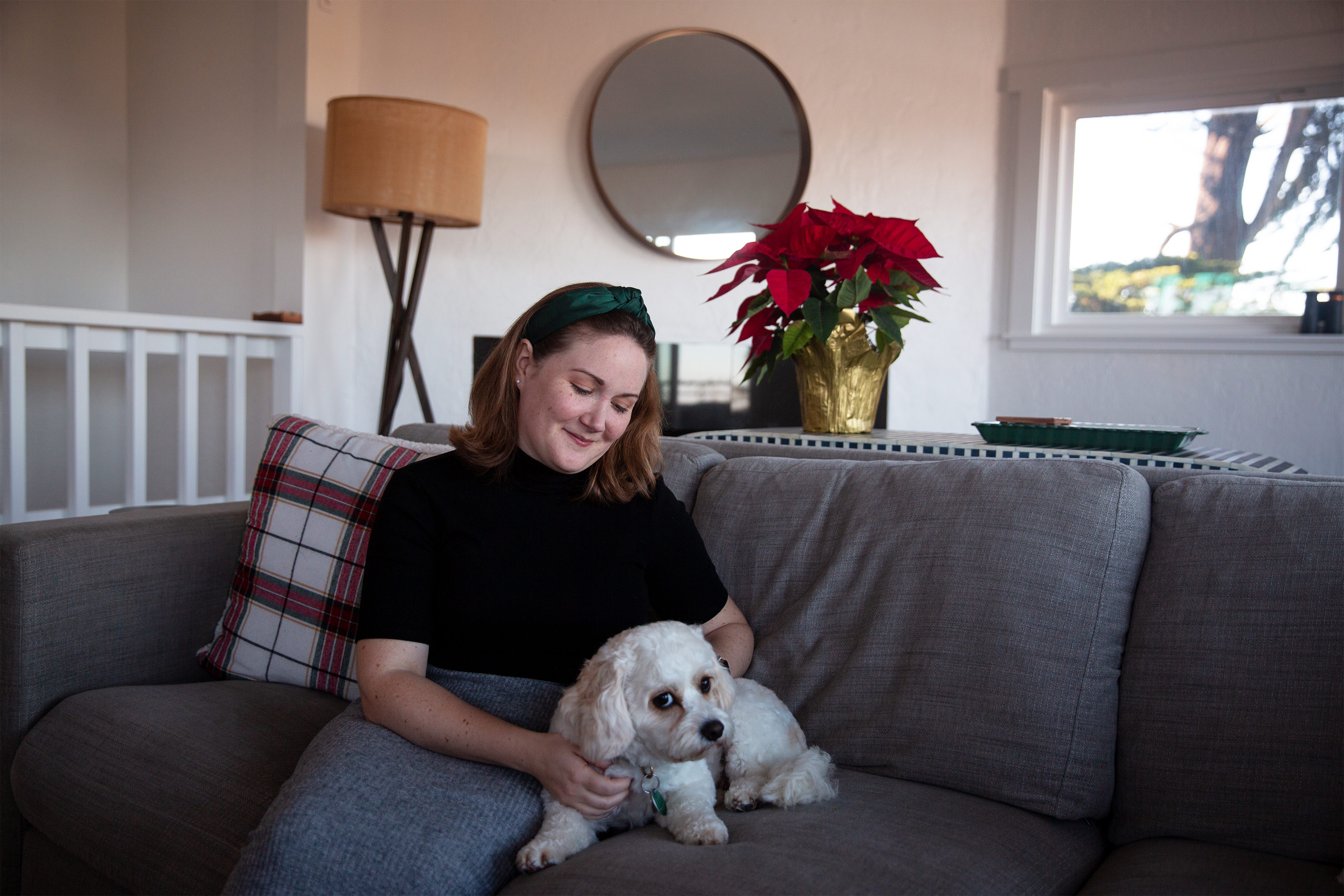 Sebuah foto memperlihatkan Grace E. Elliott duduk di sofa di rumah, membelai anjingnya.