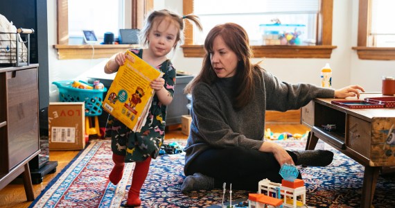 A photo shows Brenna Kearney sitting at home as her daughter, Joey, plays.