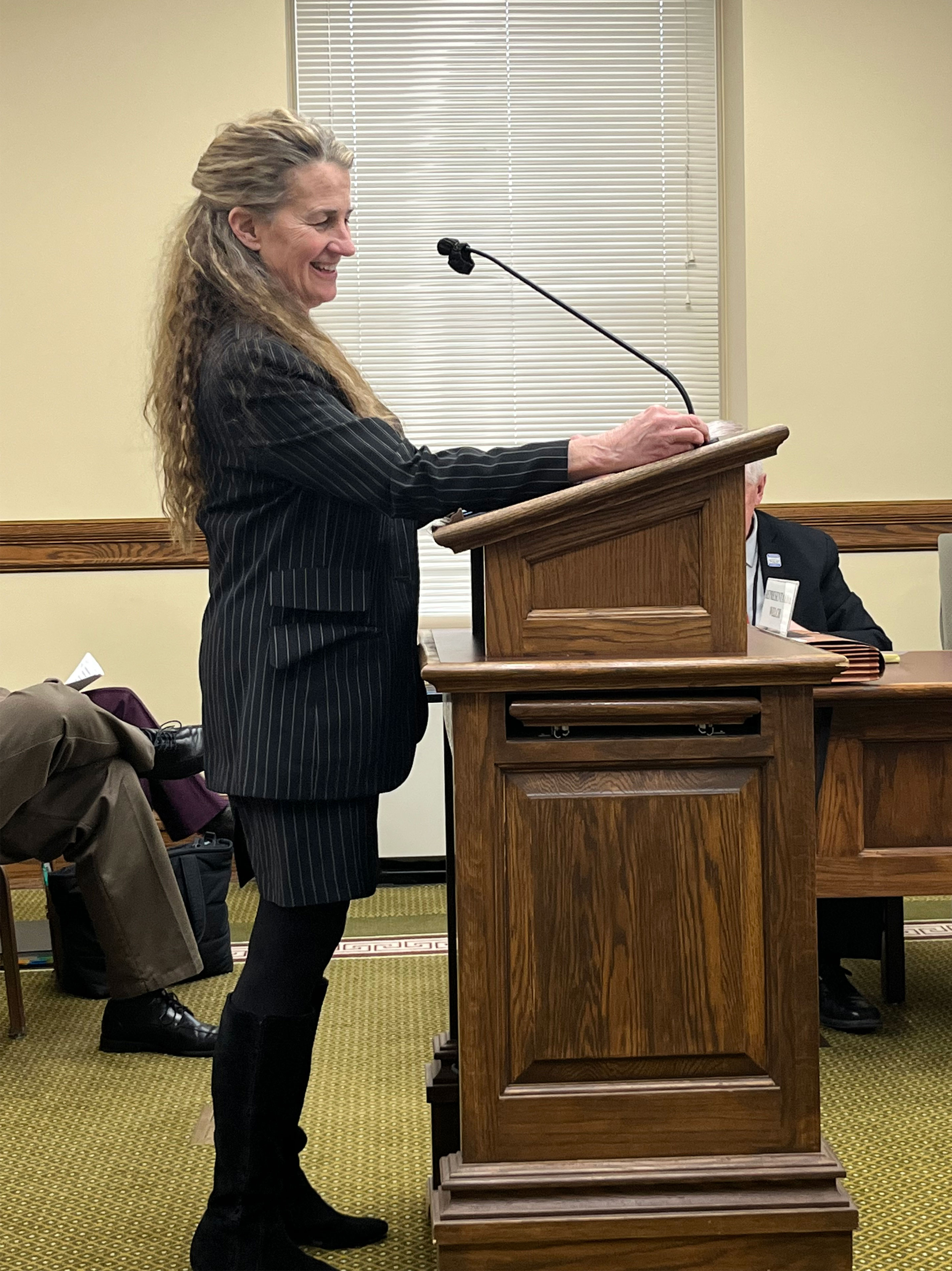 A photo shows Rep. Mary Caferro speaking at a podium.