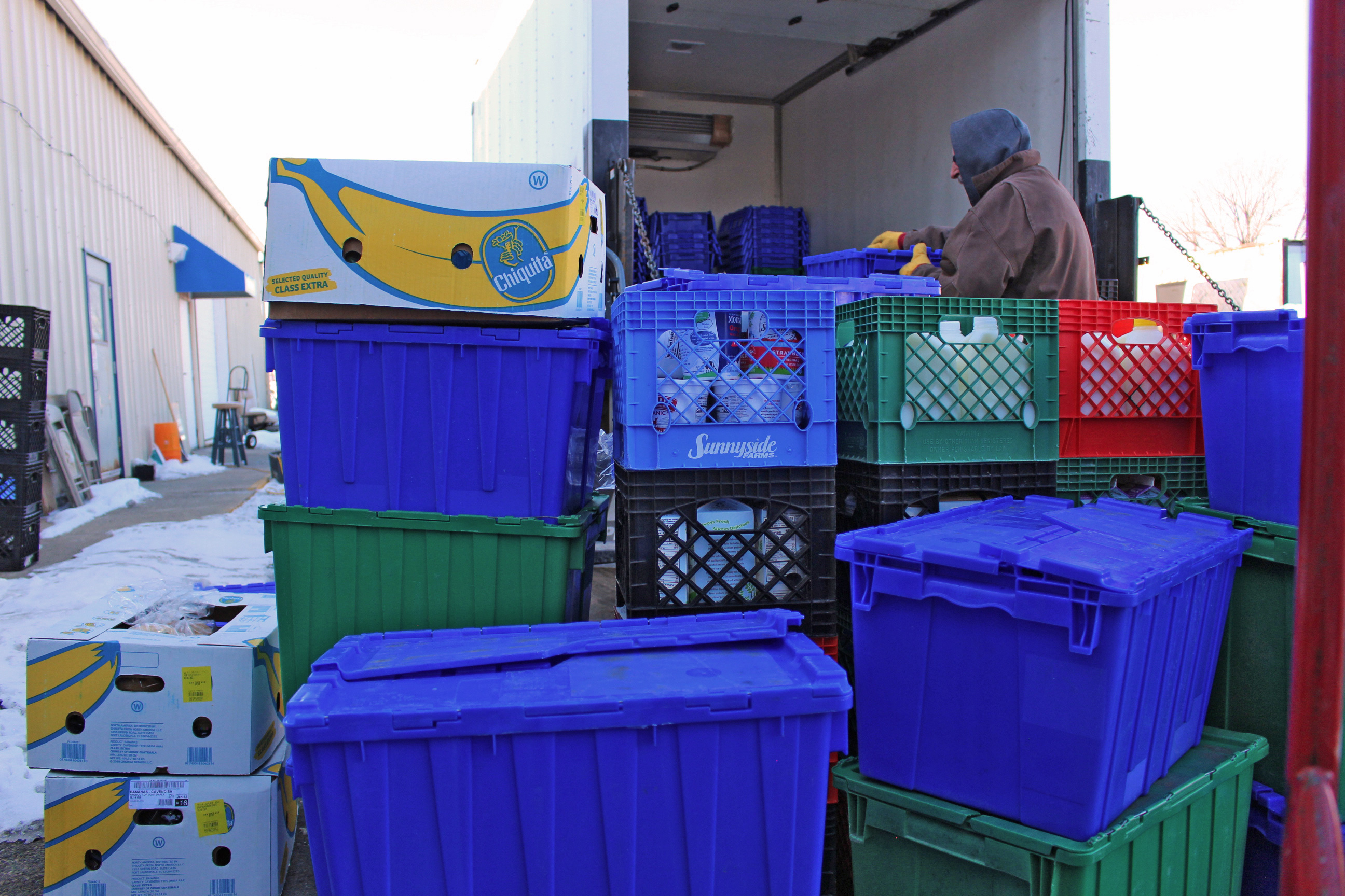A photo shows crates of food from grocery stores being dropped off from a truck.